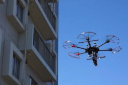 桐蔭横浜大学<br>飛行中のドローンからの音波照射加振によるタイル外壁点検。